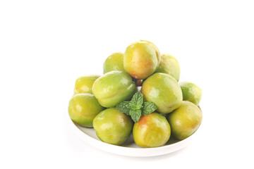 Fresh Xinjiang Green-Skinned Apricots on White Plate with Mint Garnish Isolated on White Background
