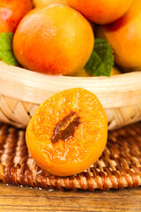 Fresh Glistening Apricots in Wicker Basket with Halved Fruit Showing Juicy Interior