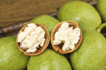 Fresh Green Walnuts with Cracked Shells Showing White Nutmeat in Studio Photography