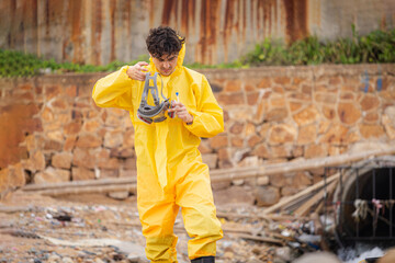 Scientist in Hazmat Suit Prepares to Test Water Quality, Male Scientist with Gas Mask in Rubbish...