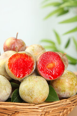 Fresh Red Plums from Gutian Orchard in Wicker Basket Showing Juicy Interior