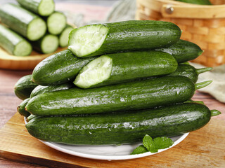 Fresh Organic Cucumbers with Water Droplets on Wooden Kitchen Counter