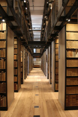 A historic library with tall wooden shelves Funders gather to discuss restoration of rare manuscripts