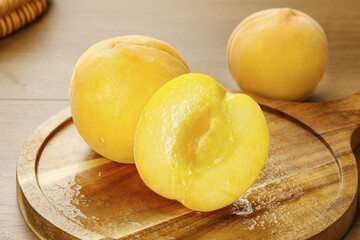 Fresh Yellow Peaches Cut in Half on Wooden Board Showing Golden Sweet Flesh