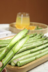 Fresh Green Asparagus Spears on Wooden Board Indoor Studio Shot with Orange Juice Background