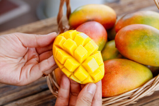 Fresh Mango Diced in Hands with Colorful Tropical Fruits in Wicker Basket