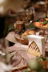 Wedding banquet table decorated with flowers, candles and food in festive hall with dark background. Concept of celebration, romance, event decoration, reception.