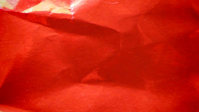 Crimson red metallic foil background, a crumpled and wrinkled paper texture