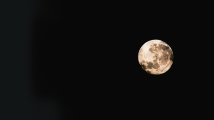 A beautiful full moon glowing brightly against a dark night sky, showcasing exquisite lunar details, creating a serene and majestic celestial ambiance perfect for astronomy and night photography. 