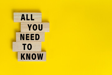 all you need to know words text symbol on wooden blocks isolated on yellow background