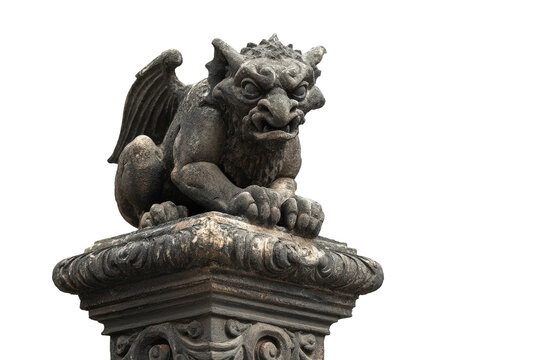 Ancient stone gargoyle statue with wings on a pedestal.