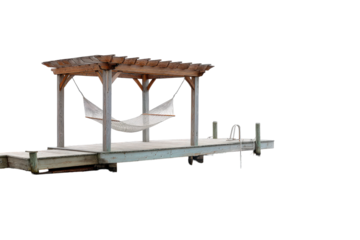 A comfortable white hammock under a wooden pergola on a dock.