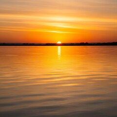Fototapeta premium A serene sunrise paints the tranquil water's surface with warm, golden hues, reflecting the fiery orb in a calm, still expanse.
