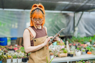 Young Asian Woman Tending to Cactus Plants with Care at a Sustainable Eco-Friendly Cactus Farm,...