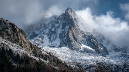 Fototapeta premium Majestic snow-capped mountain range rising through misty clouds with dramatic peaks and breathtaking panoramic view of alpine wilderness in tranquil natural landscape