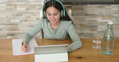 Female kid study at home using digital tablet and wireless headphone - Education, back to school and teenager lifestyle concept - Powered by Adobe