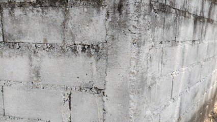 Obraz premium A gritty corner of a white concrete block wall, showing weathered textures and raw construction lines. Perfect for use in architectural references, background textures, or industrial-themed design pro
