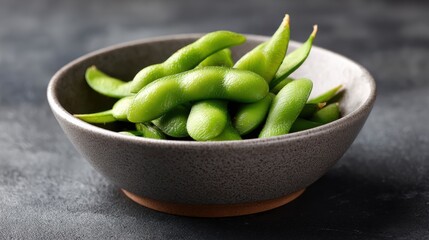 Fresh Edamame Soybeans in a Dark Ceramic Bowl on a Wooden Surface, Close-up Visual of Healthy Plant-Based Snack with Bright Green Color and Smooth Texture