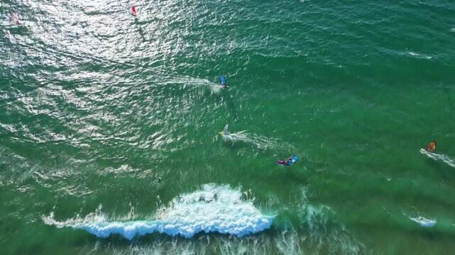 Aerial view from the sun reflected at sea with several windsurfers enjoying the good conditions of wind,Portugal