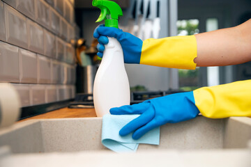 Using cleaning products for cleaning table in kitchen at home. Housekeeping, household chores.