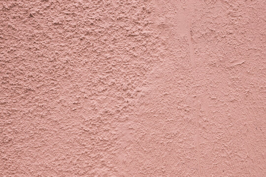 Close-up of the texture of rough, worn plaster.