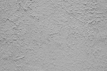 Distressed grey plaster on a concrete wall.