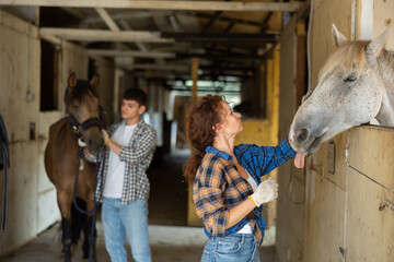 Portrait of woman next to horse in a stable stall