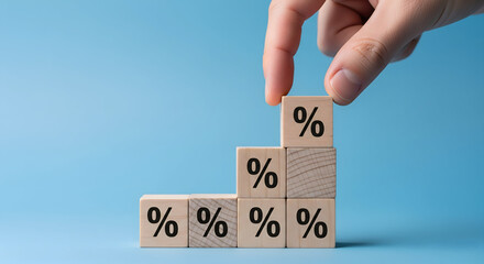 Hand stacks wooden blocks with percentage symbols creating a rising graph for financial growth