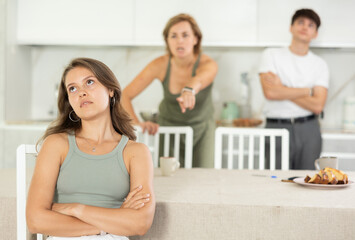 Woman and young guy swear at girl. Mom and older brother scold young girl for unsuccessful studies...