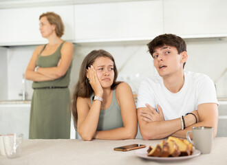 Mom make claims to young couple in home kitchen