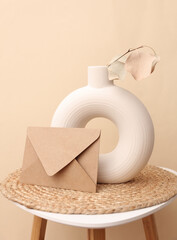 Envelope and Scandinavian style round vase with dry grass on table. Mockup for design