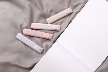 Open sketchbook with markers lies on the bed sheet