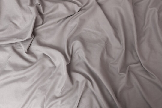 Texture of gray bed sheet, wavy fabric background