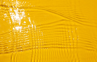 Wavy water texture with sun light on yellow background