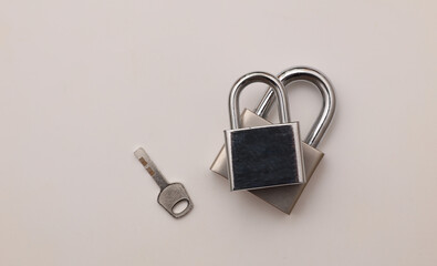 Two metal locks and key on a gray background