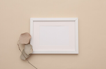 Mockup of white photo frame with dry grass on beige background