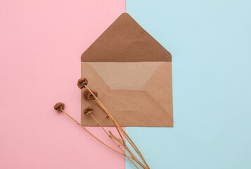 Craft envelope with dry grass on pink blue background