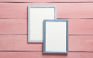 Fototapeta premium Blank wall frames on pink wooden background
