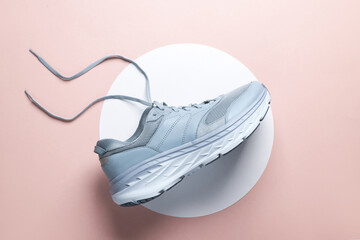 Blue sneaker on a white circles. Pink background. Creative idea. Fashion concept. Top view