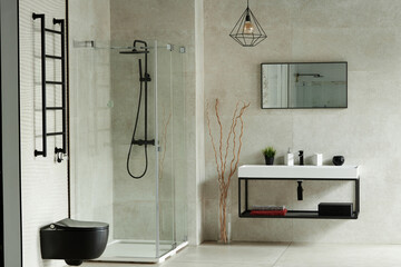 Modern bathroom interior featuring glass shower enclosure, wall mounted black toilet, rectangular...