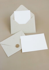Beige envelopes with blank paper card mockup  inside top view and empty blank paper on beige background . Copy space.Minimalist aesthetic wedding invitation mockup, greeting card, holiday concept.