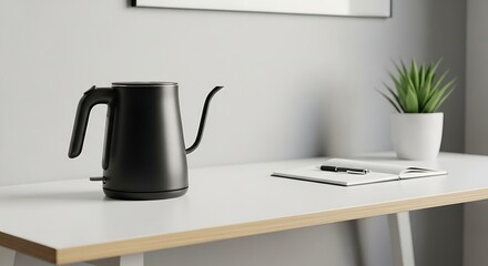 Modern black tea kettle and notepad on desk
