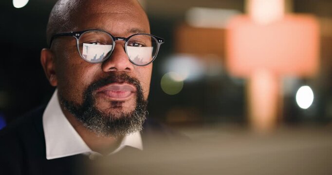 Black man, reading and graphs on computer in office for accounting, finance results and night. Mature person, pc and glasses reflection of financial charts, profit growth and stats for audit deadline