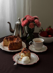 Homemade tea party - apple pie with ice cream, coffee, floral decor on a round table with a brown tablecloth
