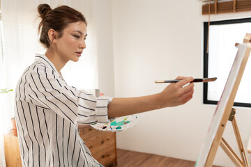 female hobbies about artist and use paintbrush in abstract art for create masterpiece. painter paint with watercolors or oil in studio house. enjoy painting as hobby, recreation, inspiration