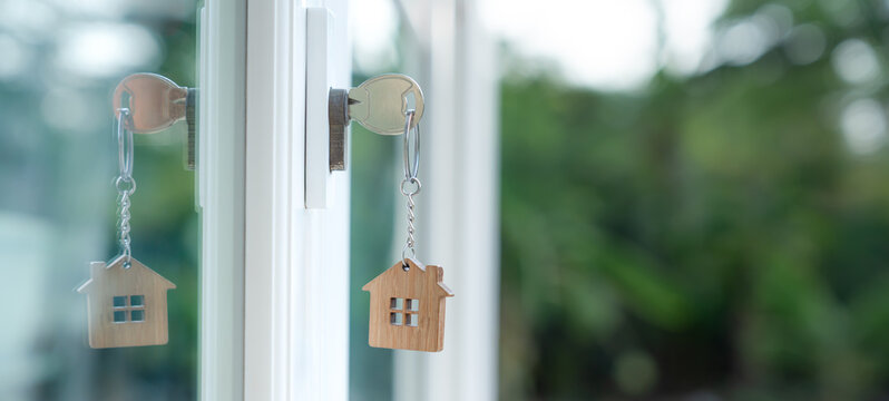 Landlord key for unlocking house is plugged into the door. Second hand house for rent and sale. keychain is blowing in the wind. mortgage for new home, buy, sell, renovate, investment, owner, estate