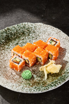 California roll with tobiko and cucumber, bright lighting, overhead composition on artisanal ceramic plate