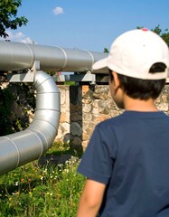 Child looking at large metal pipes
