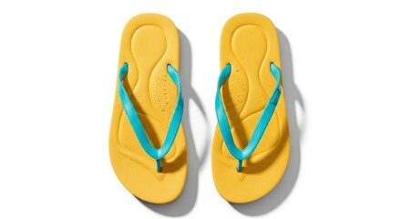 Fototapeta premium A pair of yellow flip-flops with blue straps rests on a white surface casting distinct shadows