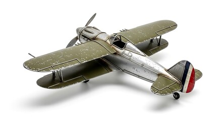 A weathered olive-green and silver model aircraft with a propeller and striped tail casting a shadow on a white surface